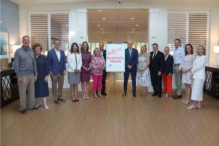 Group of professionals at Quantum House welcoming event in a modern indoor setting.