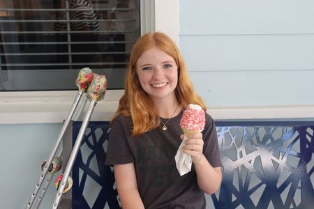 Smiling young woman with red hair enjoying ice cream outside Quantum House.